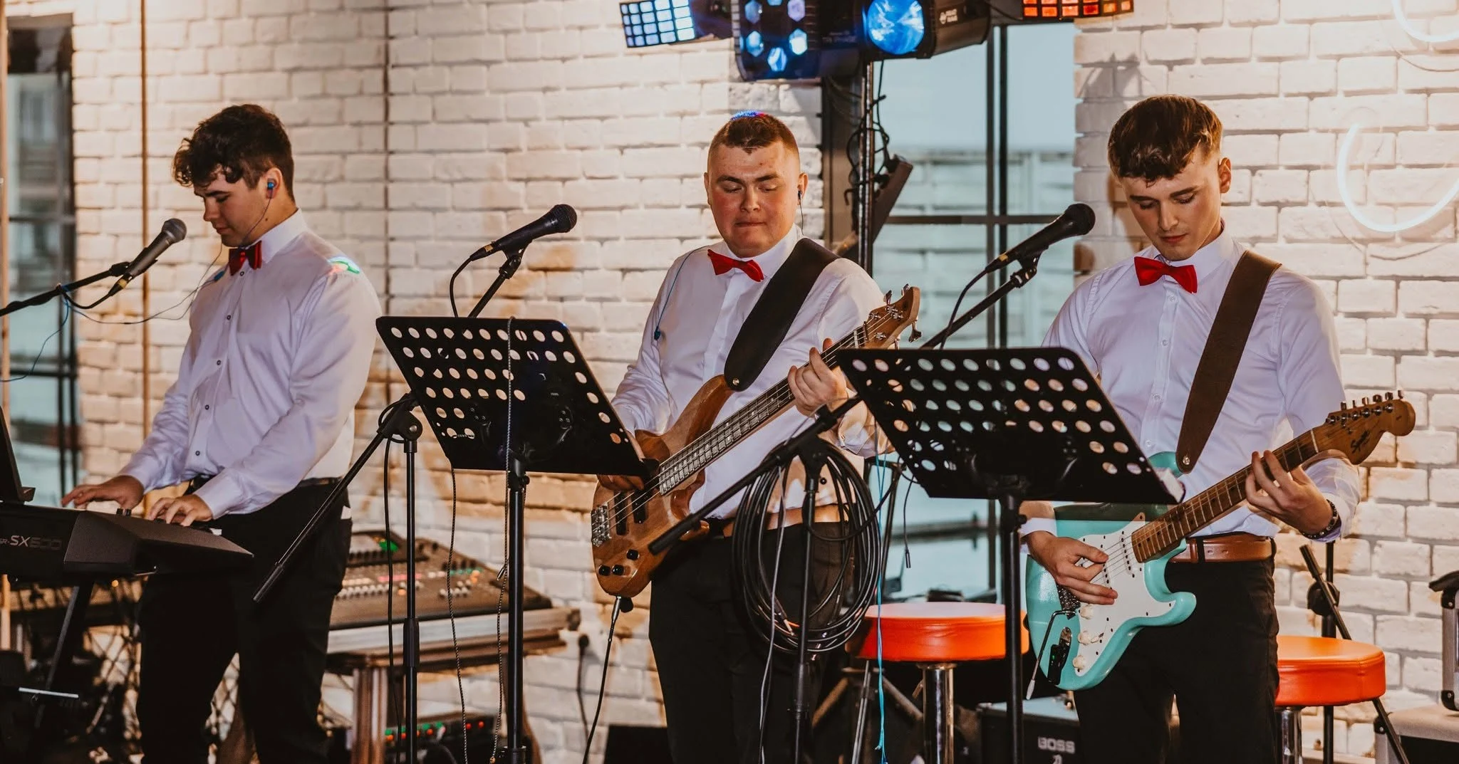 Keyboardzista, basista i gitarzysta Torino podczas grania na scenie.