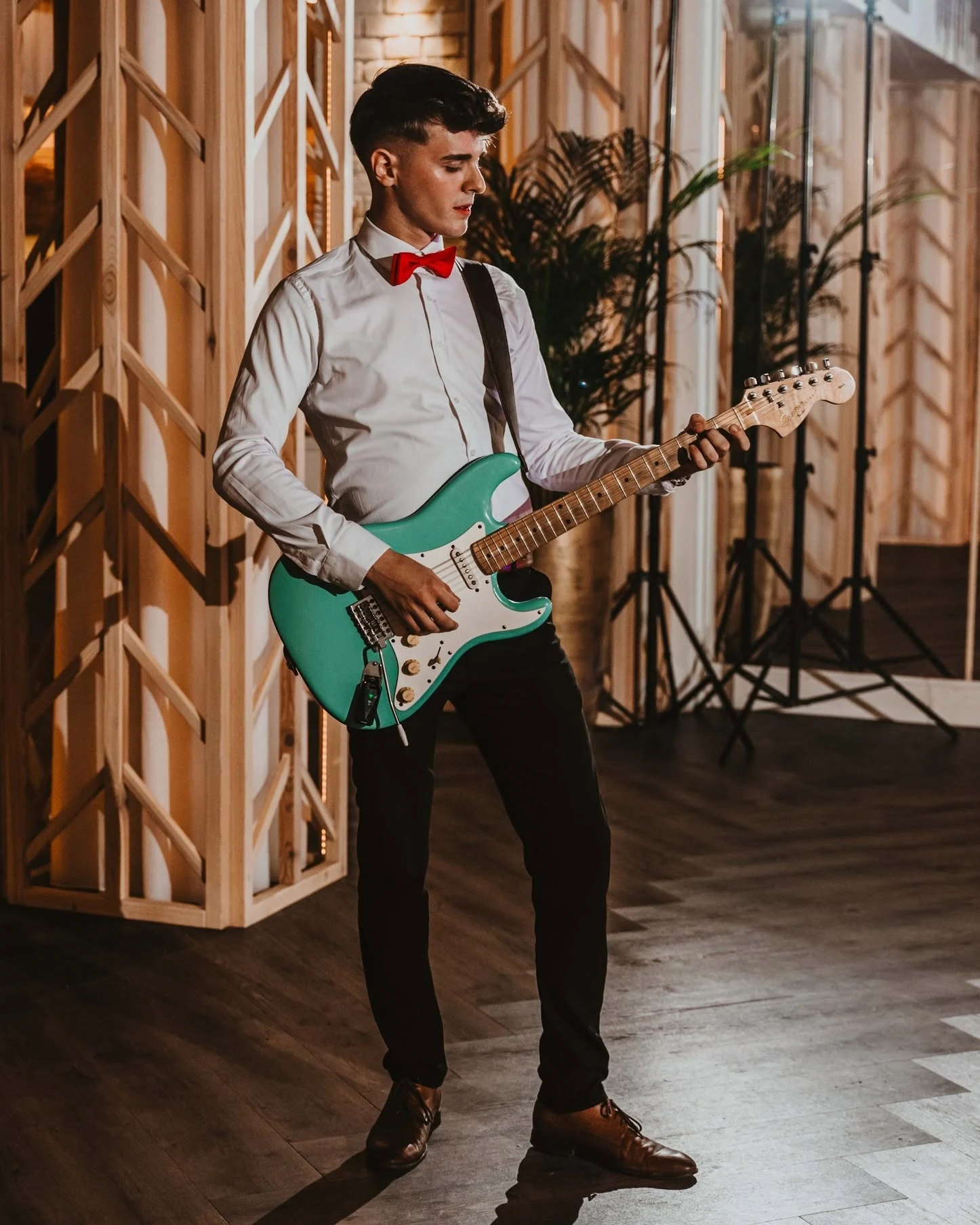 Gitarzysta Torino z zieloną gitarą elektryczną podczas występu.